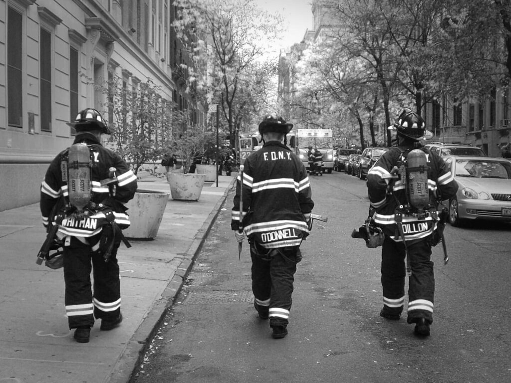 pompieri USA di spalle si allontanano, foto in bianco e nero