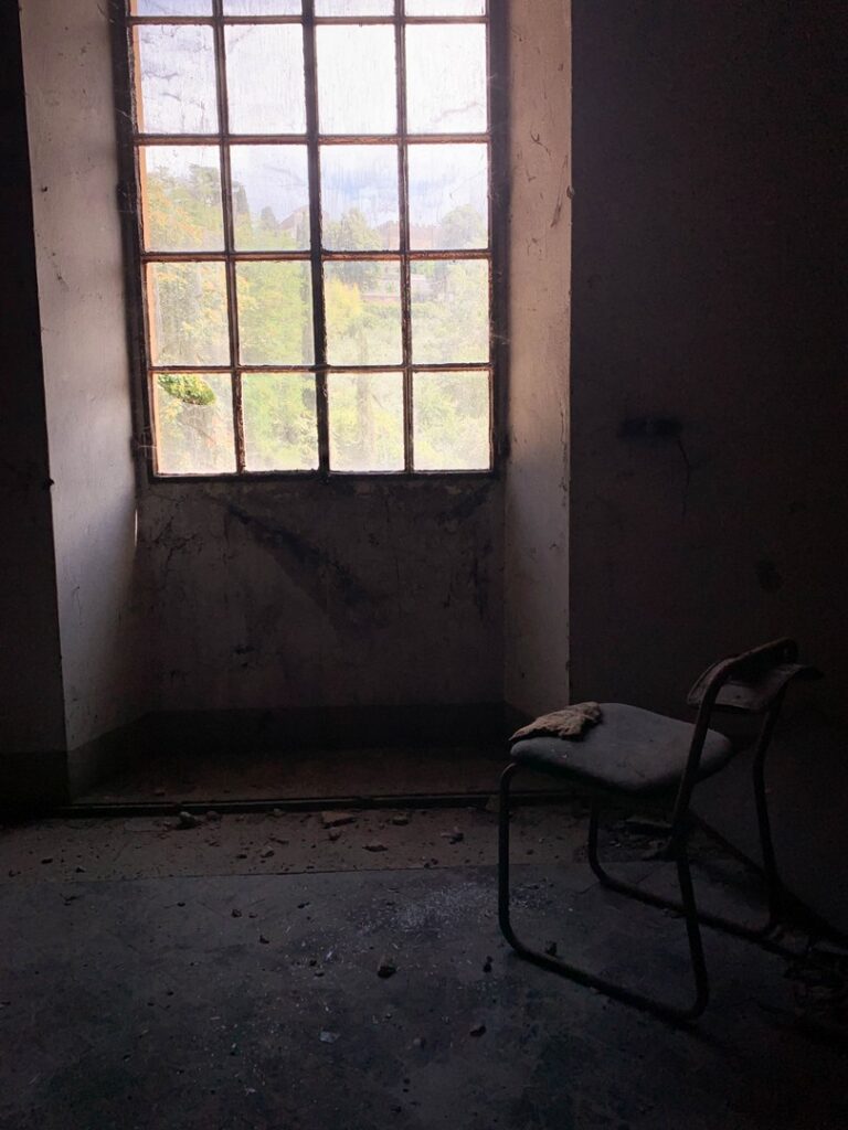 sedia cicino a finestra in una casa abbandonata, dalla finestra si vede un bellissimo panorama verde, © Lorenzo De Cicco